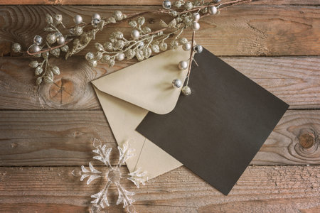 a winter themed greeting card mock up with gold envelope and ornaments. 