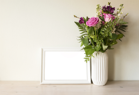 Empty frame mockup with flower bouqet in vase.の写真素材