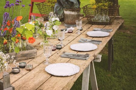 Wooden table setup for garden party or dinner reception. の写真素材