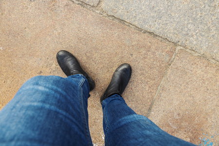 Above view of two legs in denim and boots.の写真素材