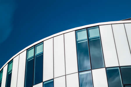 Detail of modern architecture with blue sky and window reflections.のeditorial素材