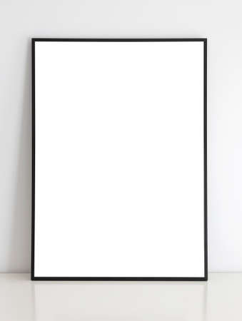 Thin black mock up frame on table with white wall.の写真素材