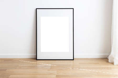 Rectangular mock up frame with passepartou standing in a room with wooden flooring.の写真素材
