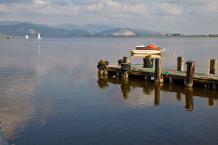 Wooden pier and boats on Lake Massaciuccoli. Lucca Tuscany, Italy の写真素材