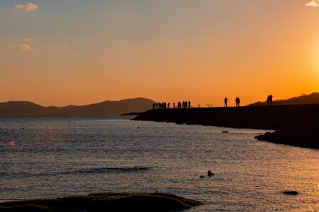 People standing on the seabankの写真素材
