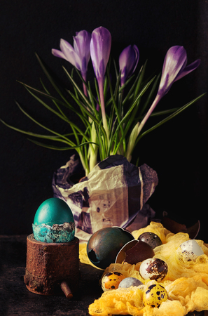 Traditional colored easter eggs with flowers and napkin over dark backgroundの写真素材
