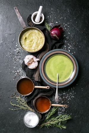 Home made broccoli and pea puree soup decorated with rosemary, thyme, garlic and onions, served with vegetable broth. Top Viewの写真素材