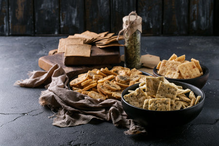 Assortment of snacks: garlic and coriander crackers, chips and biscuits served with oregano and...