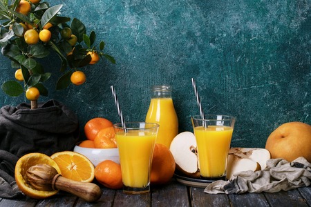 Orange Juice served with oranges, tangerines and korean pear with a mini-oranges tree on the background. Drink Conceptの写真素材