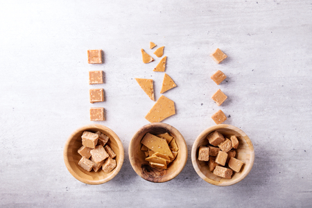 Handmade crumbly fugde in a wooden bowl over white background. Top viewの写真素材