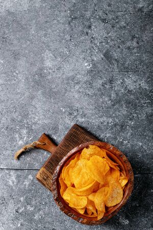 Bowl of home made potato paprika chips on dark texture background. Top view, flat lay. Copy spaceの写真素材