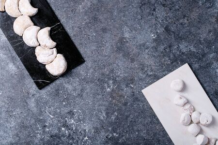 Variety of traditional Greek sweets cookies kourabiedes and akanes lukum in sugar powder over blue texture background. Top view, flat layの写真素材