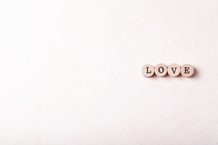 Word love made with wooden circle stamps over white texture background. Top view, flat lay. Copy spaceの写真素材