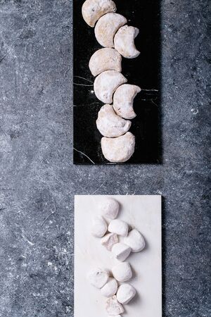 Variety of traditional Greek sweets cookies kourabiedes and akanes lukum in sugar powder over blue texture background. Top view, flat layの写真素材