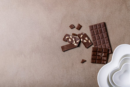 Saint valentine's day ceramic plates in shape of a heart with chocolate over brown texture...