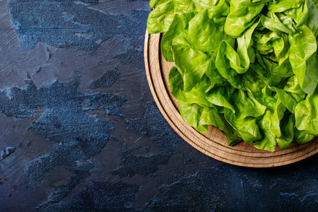 Fresh lettuce over blue texture background. Top view, flat lay. Copy space