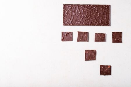 Dark chocolate over white texture background. Top view, flat lay. Copy spaceの写真素材