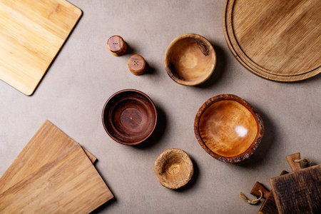 Variety of empty wooden bowls over brown texture background. Top view, flat lay. Copy space