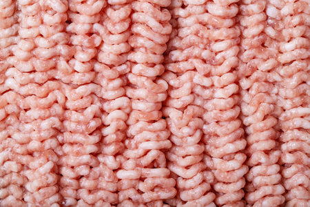 Raw minced meat in plastic packaging over white texture backdround. Top view, flat lay. Copy space