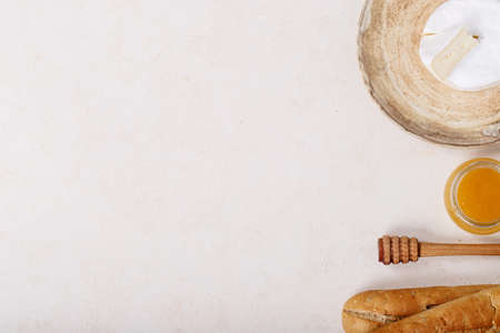 Glass of red wine served with cheese camembert, honey, jam and french baguette over dark texture background. Top view, flat lay. Copy spaceの写真素材
