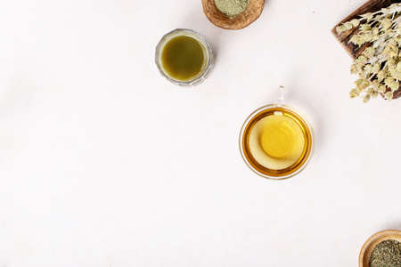 Variety of green, black and matcha tea with glass cups, wooden bowls and teapot over a white texture background. Top view. Copy Spaceの写真素材