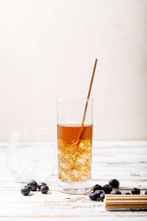 Cup and jar of peach ice tea served with fresh peach an berries over white textire backgroundの写真素材