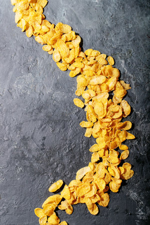 Golden cerials served with strawberry, blueberry and mint over dark texture background. Top view,...