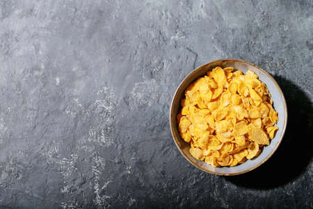 Golden cerials served with strawberry, blueberry and mint over dark texture background. Top view, flat lay. Copy spaceの写真素材