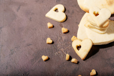 Handmade cookies in shape of heart over brown texture backgroundの写真素材