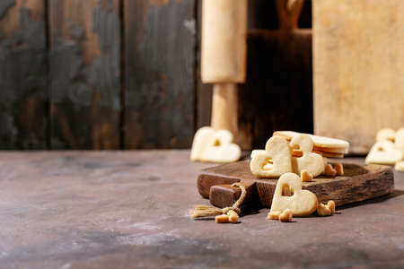 Handmade cookies in shape of heart over brown texture backgroundの写真素材
