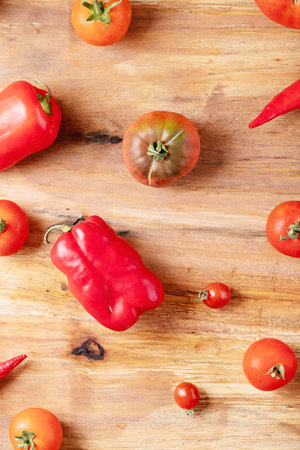 Fresh red tomatoes over brown wooden background. Top view, flat lay. Copy space