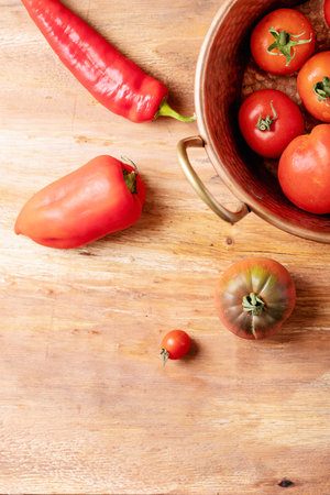 Fresh red tomatoes over brown wooden background. Top view, flat lay. Copy space