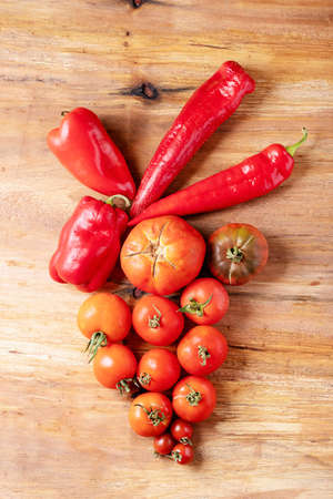Fresh red tomatoes over brown wooden background. Top view, flat lay. Copy spaceの写真素材