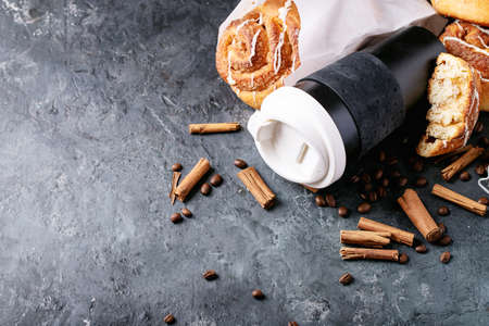 Baked cinnamon buns served with cinnamon and coffee over white texture background. Take away conceptの写真素材