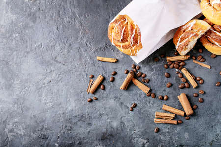 Baked cinnamon buns served with cinnamon and coffee over white texture background. Take away conceptの写真素材