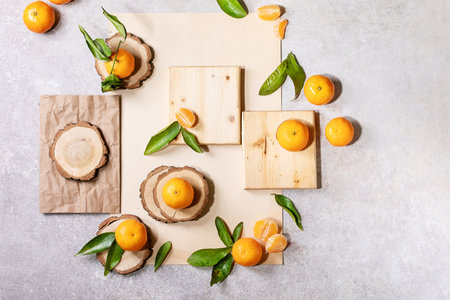 Fresh oranges with green leaves on white papper and wooden desks. Top view, flat lay. Copy spaceの写真素材