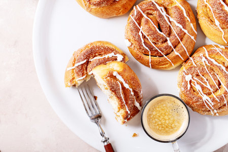 Baked cinnamon buns served with cinnamon and coffee over white texture background. Top view, flat lay. Copy spaceの写真素材