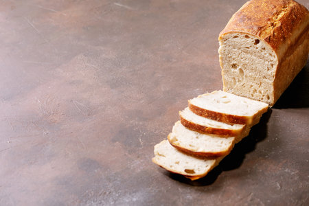 Homemade sliced white bread over brown texture backgroundの写真素材
