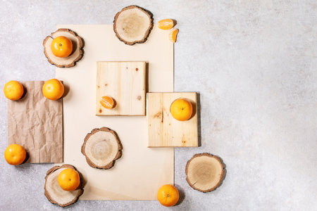 Fresh oranges with green leaves on white papper and wooden desks. Top view, flat lay. Copy spaceの写真素材
