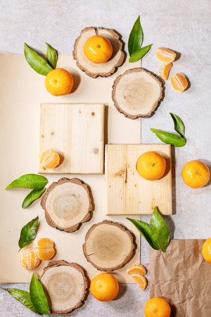 Fresh oranges with green leaves on white papper and wooden desks. Top view, flat lay. Copy spaceの写真素材