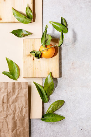Fresh oranges with green leaves on white papper and wooden desks. Top view, flat lay. Copy spaceの写真素材