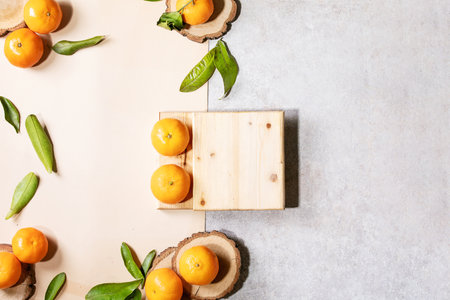 Fresh oranges with green leaves on white papper and wooden desks. Top view, flat lay. Copy spaceの写真素材