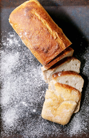 Homemade sliced white bread over brown texture background. Top view, flat lay. Copy spaceの写真素材