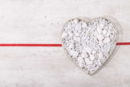 St. Valentines Day heart decorated with white rocks over bright wooden background. Top view, flat lay. Copy spaceの写真素材
