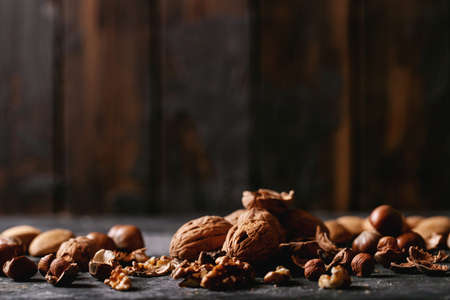 Varieties of nuts: almonds, hazelnuts and walnuts over dark texture backgroundの写真素材