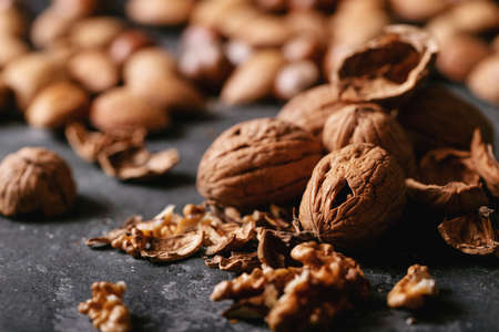 Varieties of nuts: almonds, hazelnuts and walnuts over dark texture backgroundの写真素材
