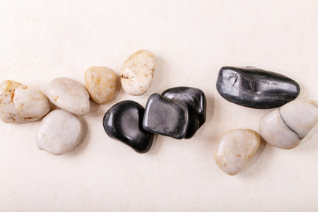 White, black decorative rocks and pebbles over grey wooden background. Creative layoutの写真素材
