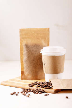 Take away paper cup, coffee beans and coffee packs with blank space for over white texture background. Copy spaceの写真素材