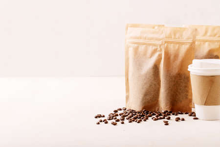 Take away paper cup, coffee beans and coffee packs with blank space for over white texture background. Copy spaceの写真素材