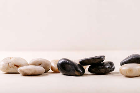 White, black decorative rocks and pebbles over grey wooden backgroundの写真素材